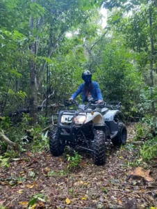 Person riding an ATV through tropical jungle trails during a Cozumel ATV tour in Mexico