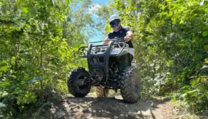 Person riding an ATV through jungle trails during a Cozumel ATV tour in Mexico