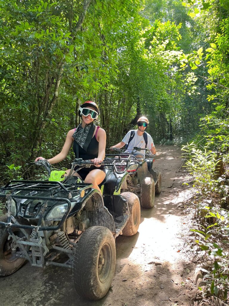 Couple enjoying an ATV tour in Cozumel Mexico through tropical jungle trails